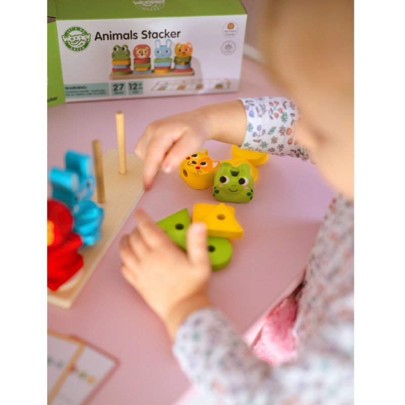 2. Child arranging colorful animal blocks on Montessori puzzle pyramid with box in background
