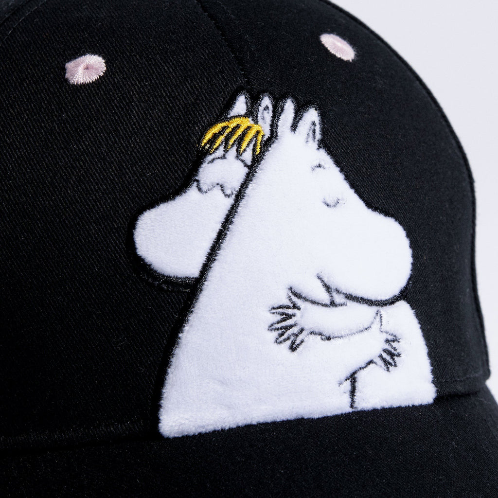 2. Close-up of Moomin Love kids' cap showing embroidered Moomin characters on black cotton