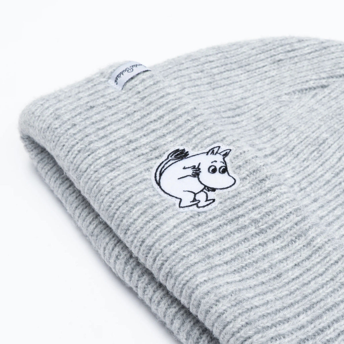 2. Close-up of grey Moomintroll beanie with felt patch and NordicBuddies label on white background