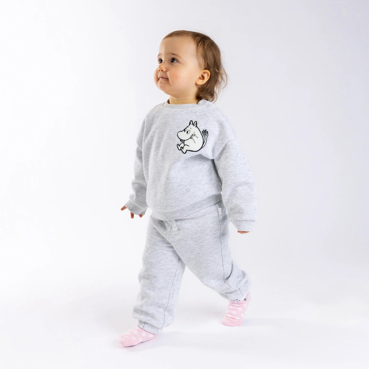 1. Toddler wearing grey Moomintroll kids college set with decorative drawstring, walking on white background