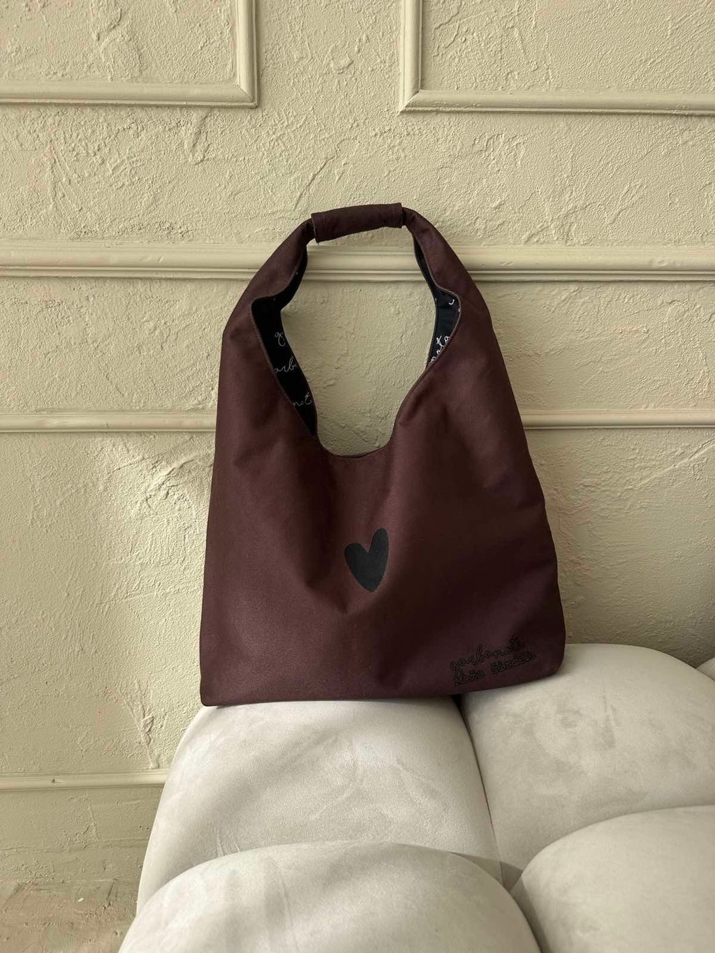 3. Garbanota Moon Bag Heart in brown on white sofa, showing interior pattern and heart detail