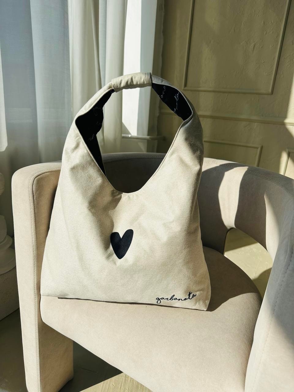6. Garbanota Moon Bag Heart in white on a chair, showing interior pattern lining