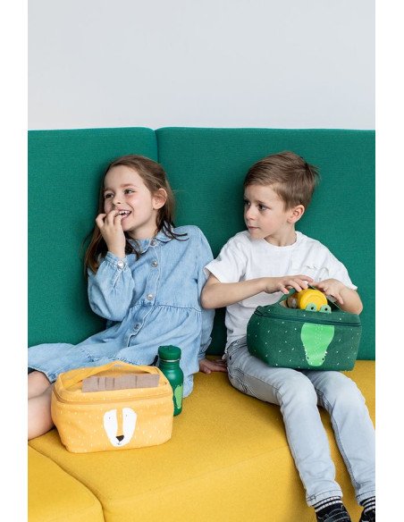1. Two children sitting on a colorful couch, one holding a green Mr. Crocodile thermal lunch bag, highlighting playful and fun design