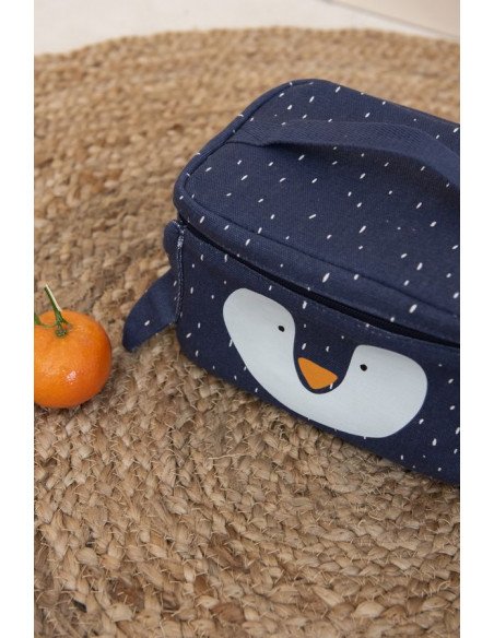 3. Close-up of Trixie Baby Mr. Penguin lunch bag on woven mat with orange, highlighting cotton texture