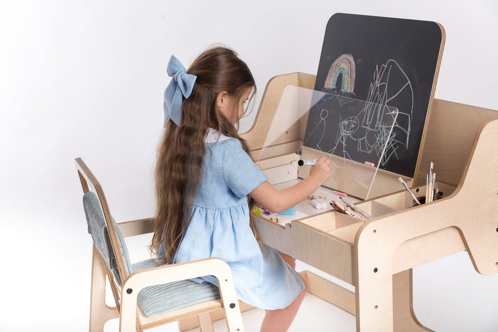 8. Girl drawing on Luula table with chalkboard and acrylic board, showcasing artistic expression