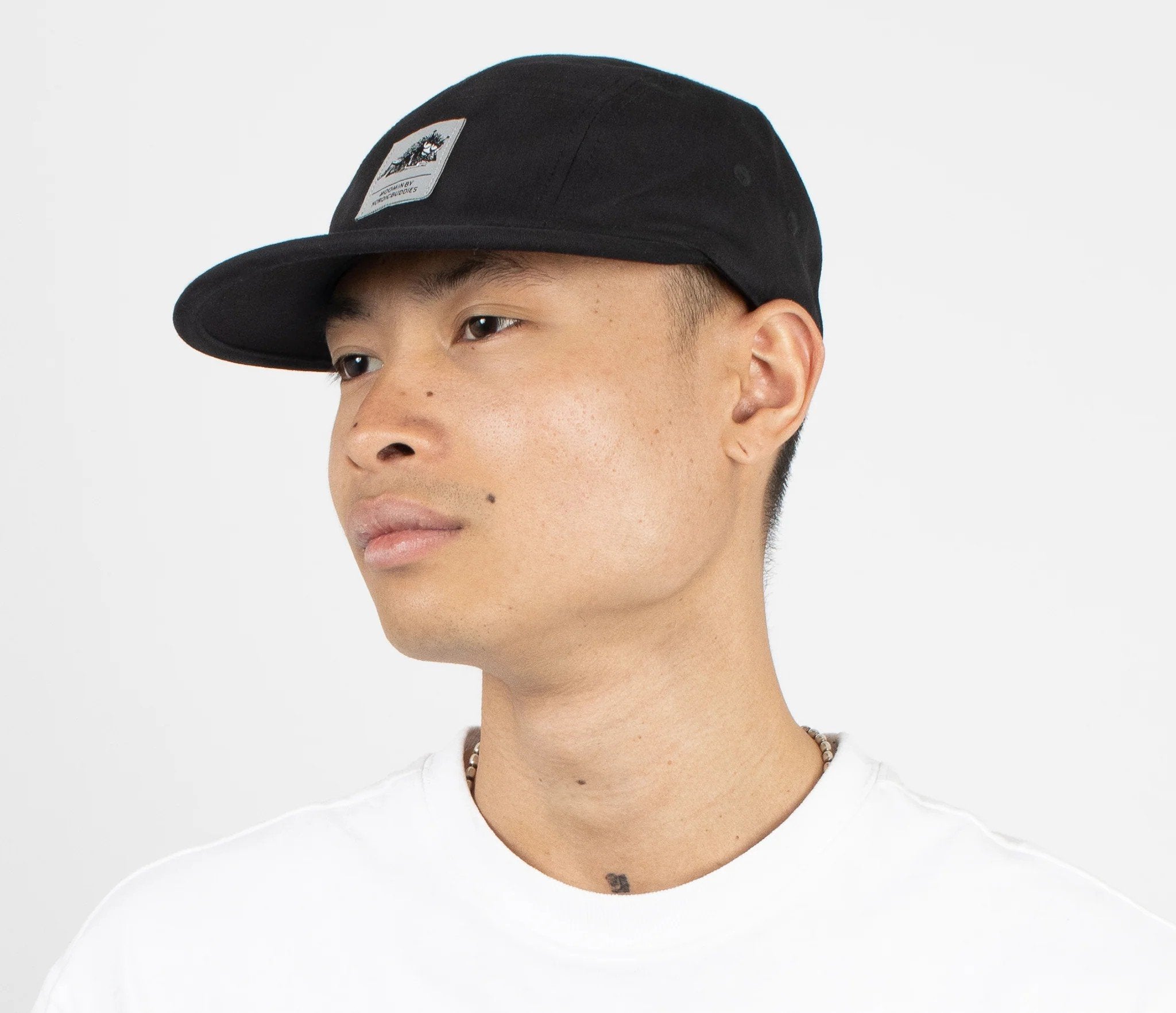 1. Men's black Stinky Five Panel Cap by Moomin, worn by model in studio setting