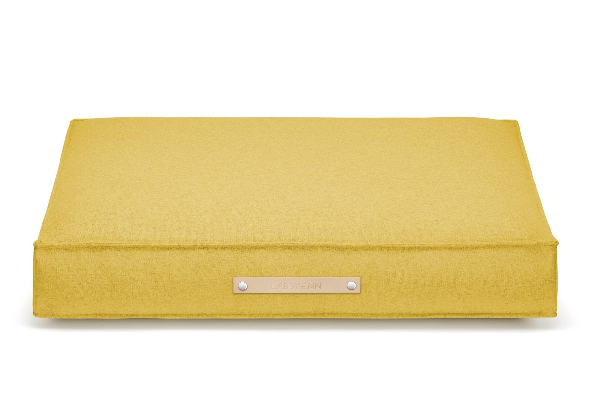 2. Labbvenn Møvik Cushion in honey color with leather belt and logo, shown in studio setting