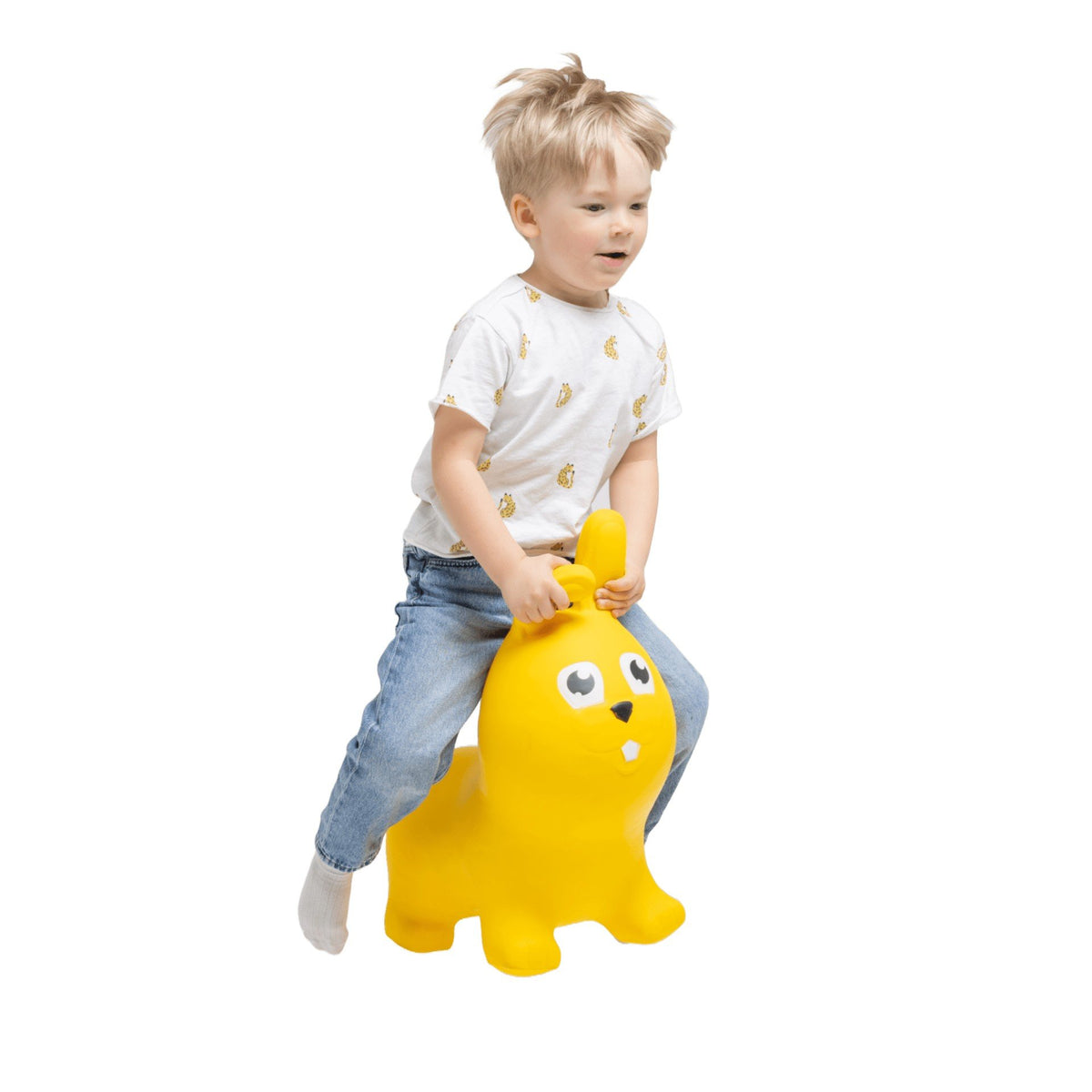 1. Young boy riding a yellow bunny-shaped hopper toy indoors, wearing a white shirt and jeans