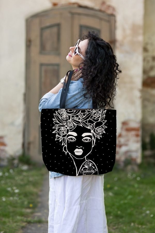 6. Woman enjoying outdoors with Garbanota Naomi handbag in black, featuring floral haircut design, styled with white dress