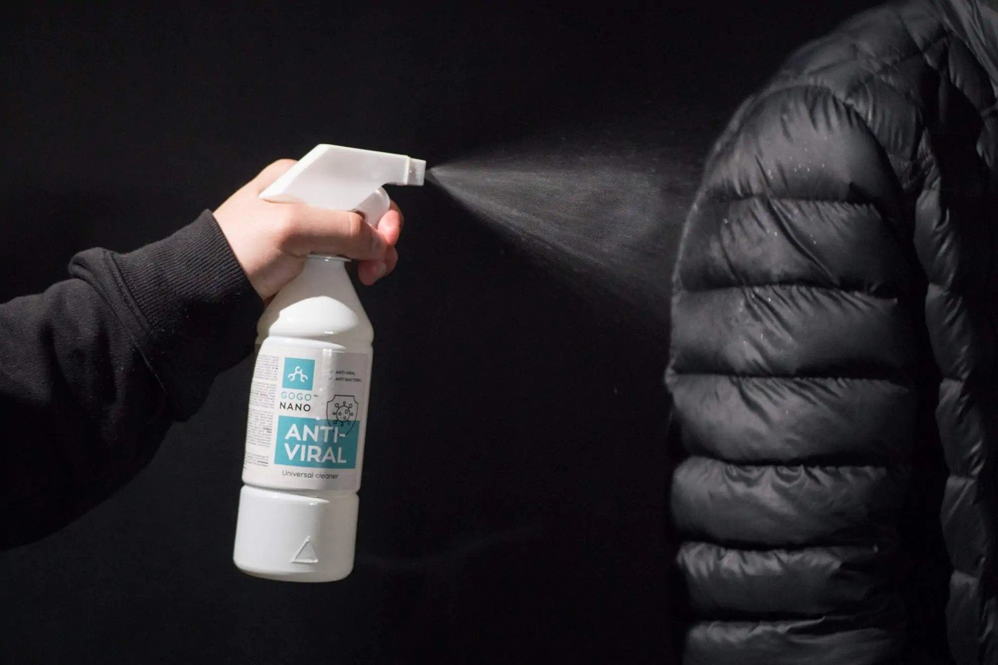 1. GoGoNano Anti-Viral cleaner being sprayed on black jacket, highlighting versatility