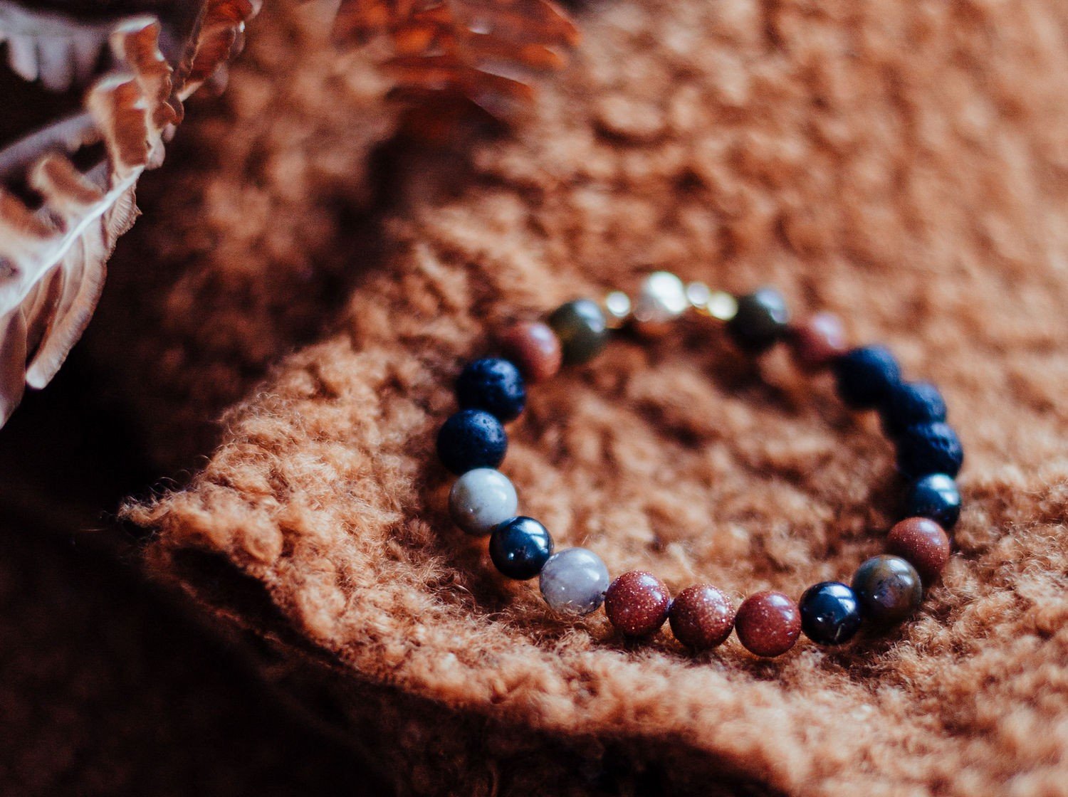 3. Natural Lava Bracelet Magic Autumn on textured fabric, highlighting polished lava rocks, hematite, Indian agate, and goldstone beads