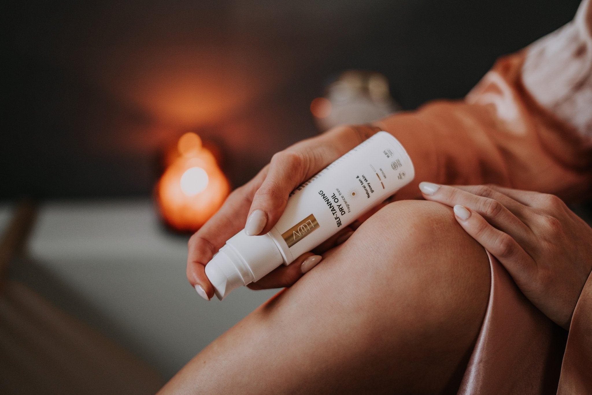 1. Woman applying LUUV Natural Self Tanning Dry Oil with mitt for even tan application