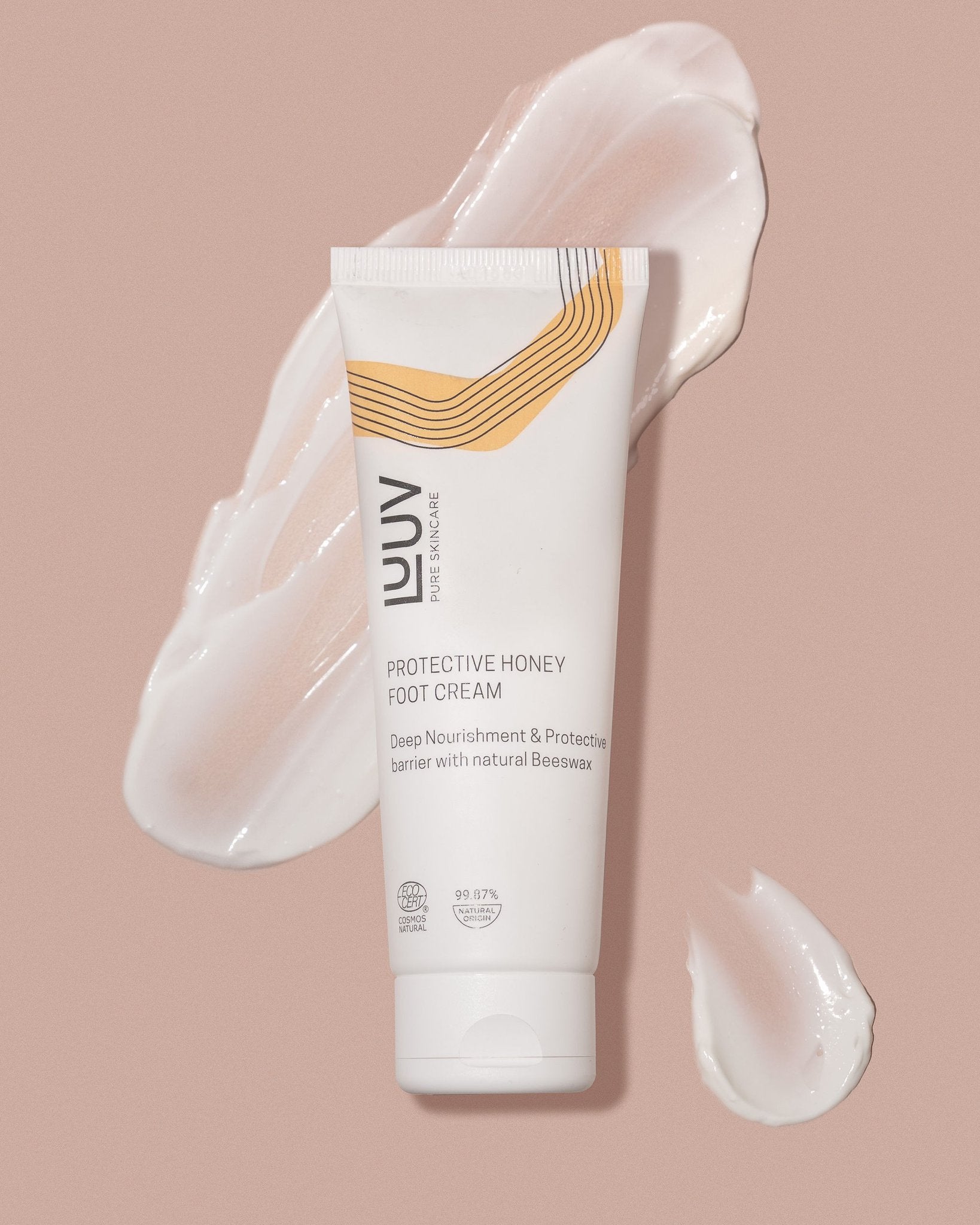 3. LUUV Protective Honey Foot Cream tube with cream swirls on pink background
