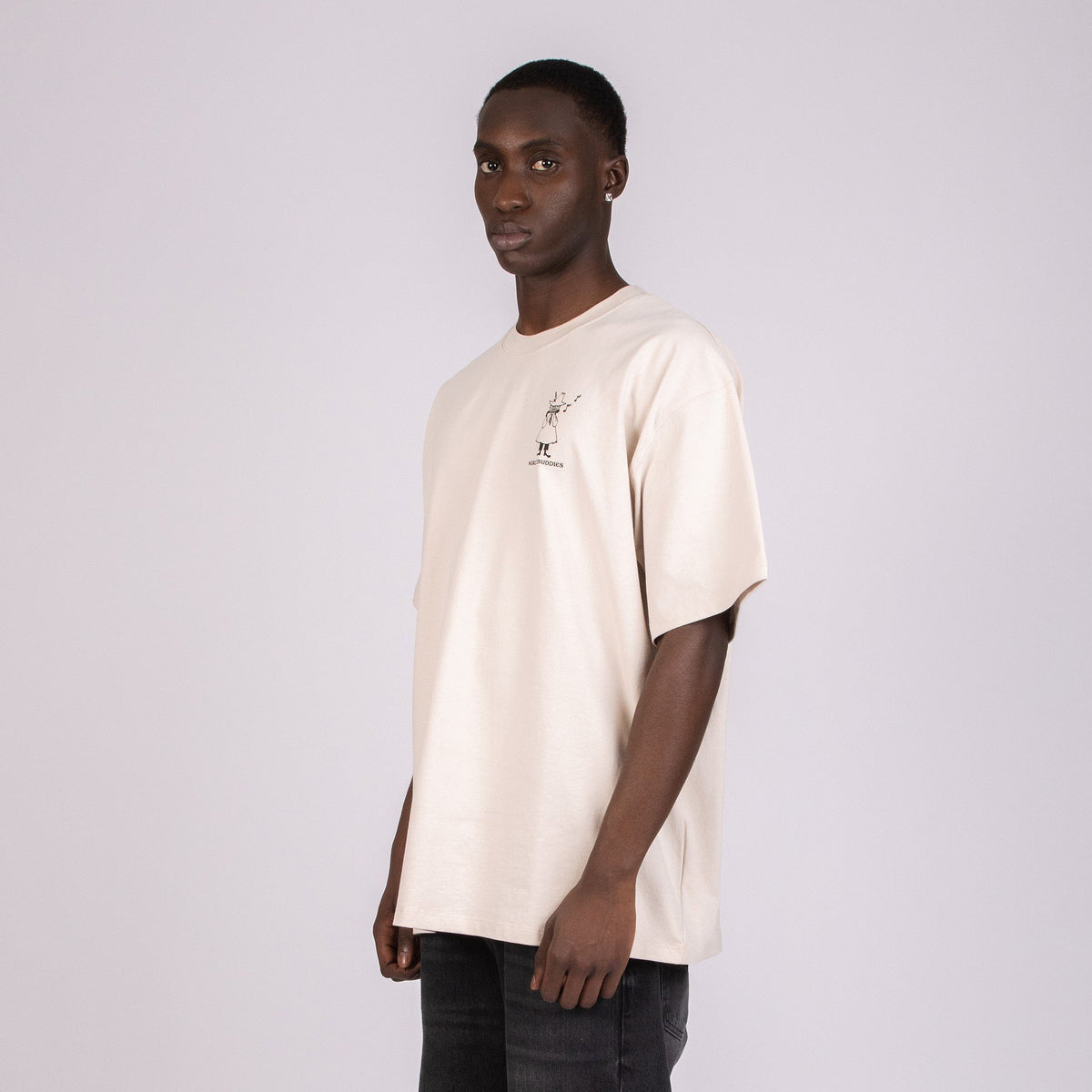 3. Male model wearing unisex beige Moomin t-shirt, showing front logo in studio
