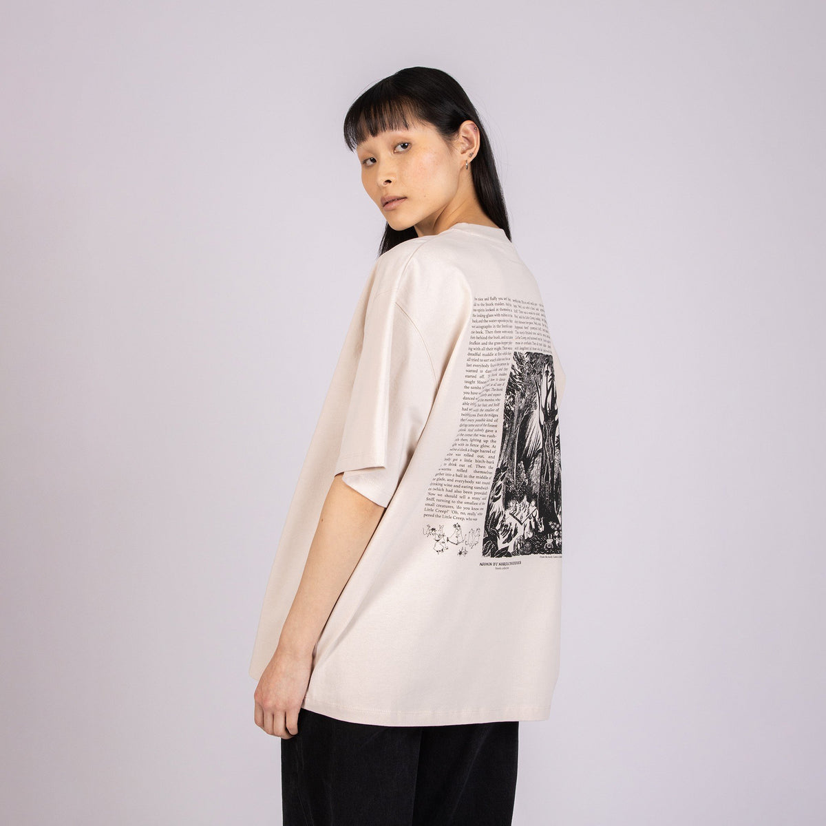 4. Female model wearing unisex beige Moomin t-shirt, highlighting back design with text and illustration
