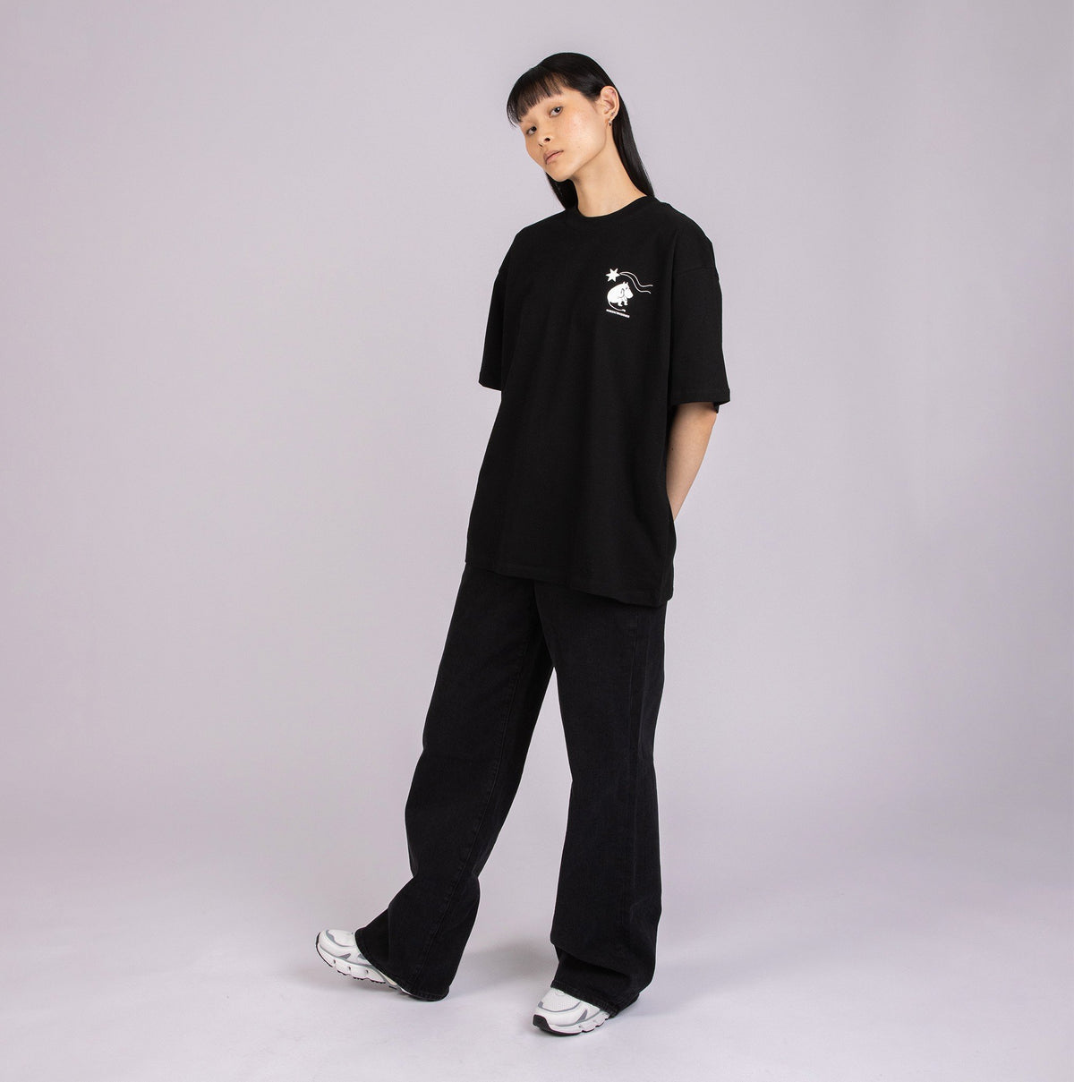 4. Female model in black Moomin t-shirt with subtle front logo, styled casually in studio