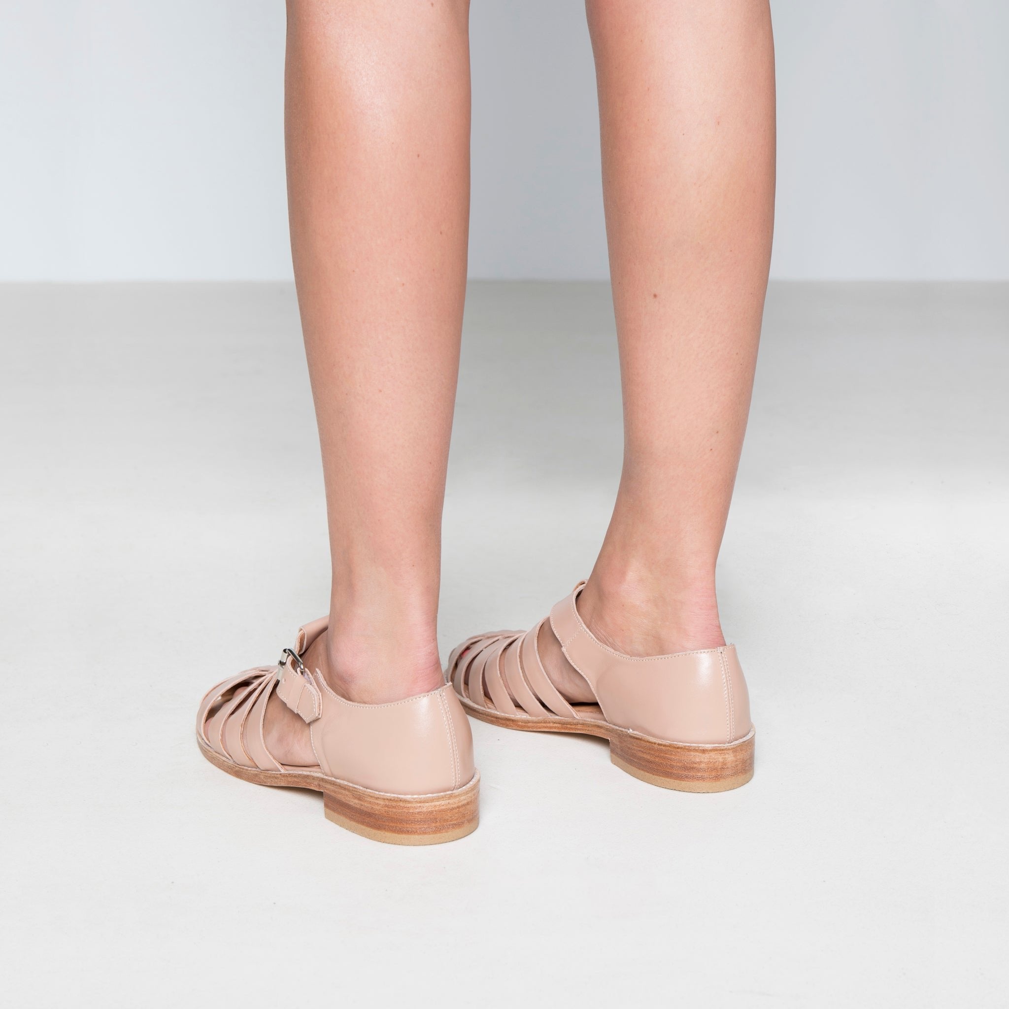 2. Back view of women's handmade leather fisherman sandals in white, highlighting round toe and stacked heel