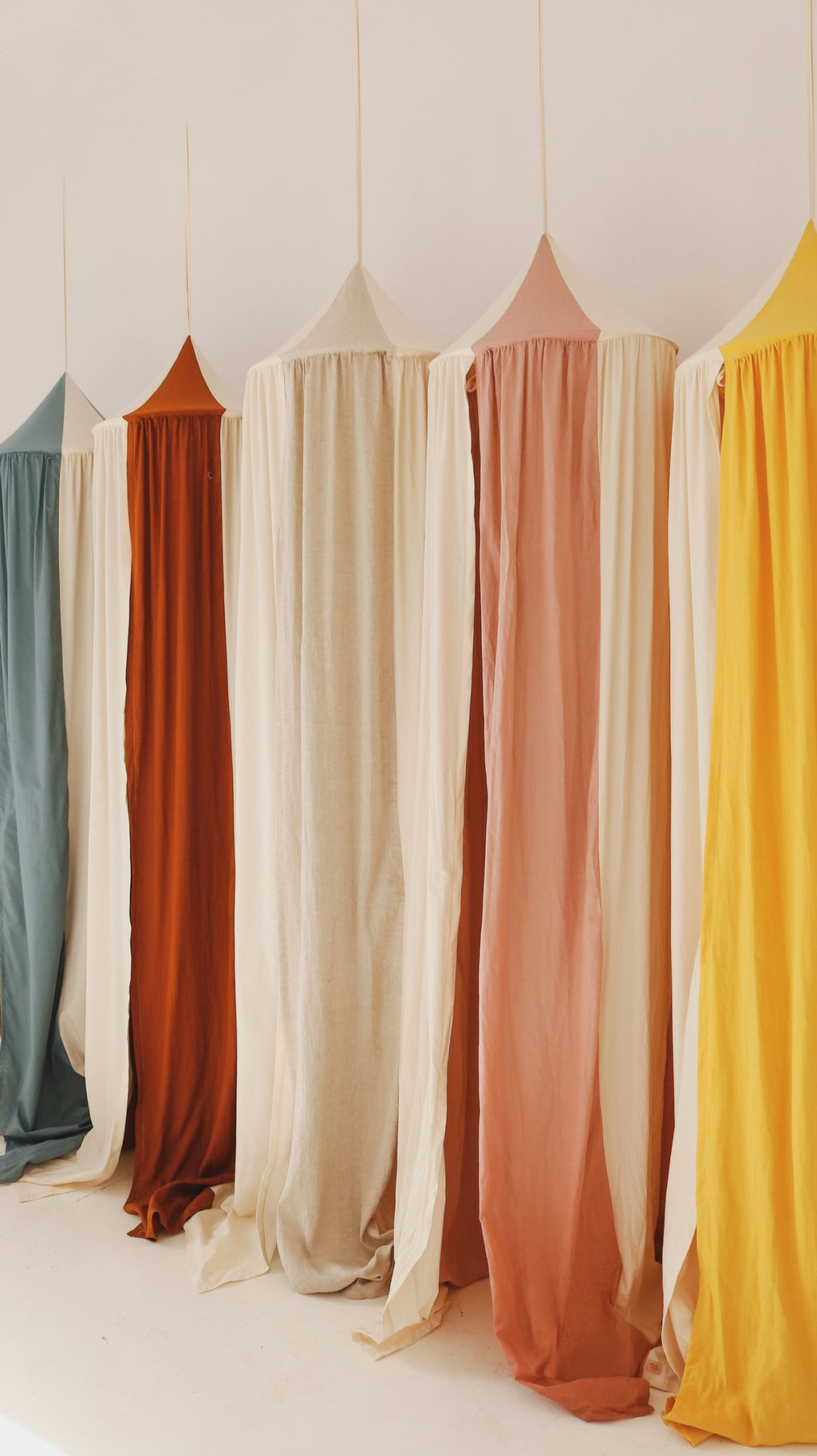 6. Row of colorful canopies including powder pink, displayed in a studio setting, highlighting variety and design.