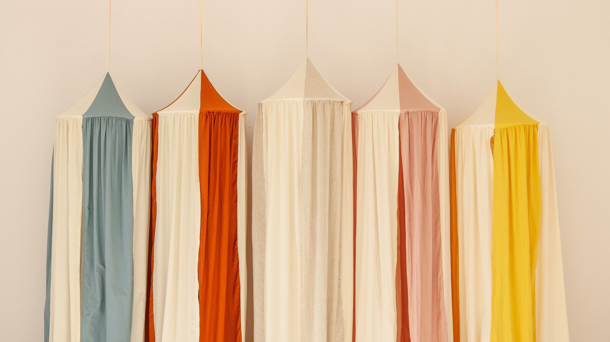 7. Assorted canopies in various colors including powder pink, hanging in a row, showcasing design diversity.