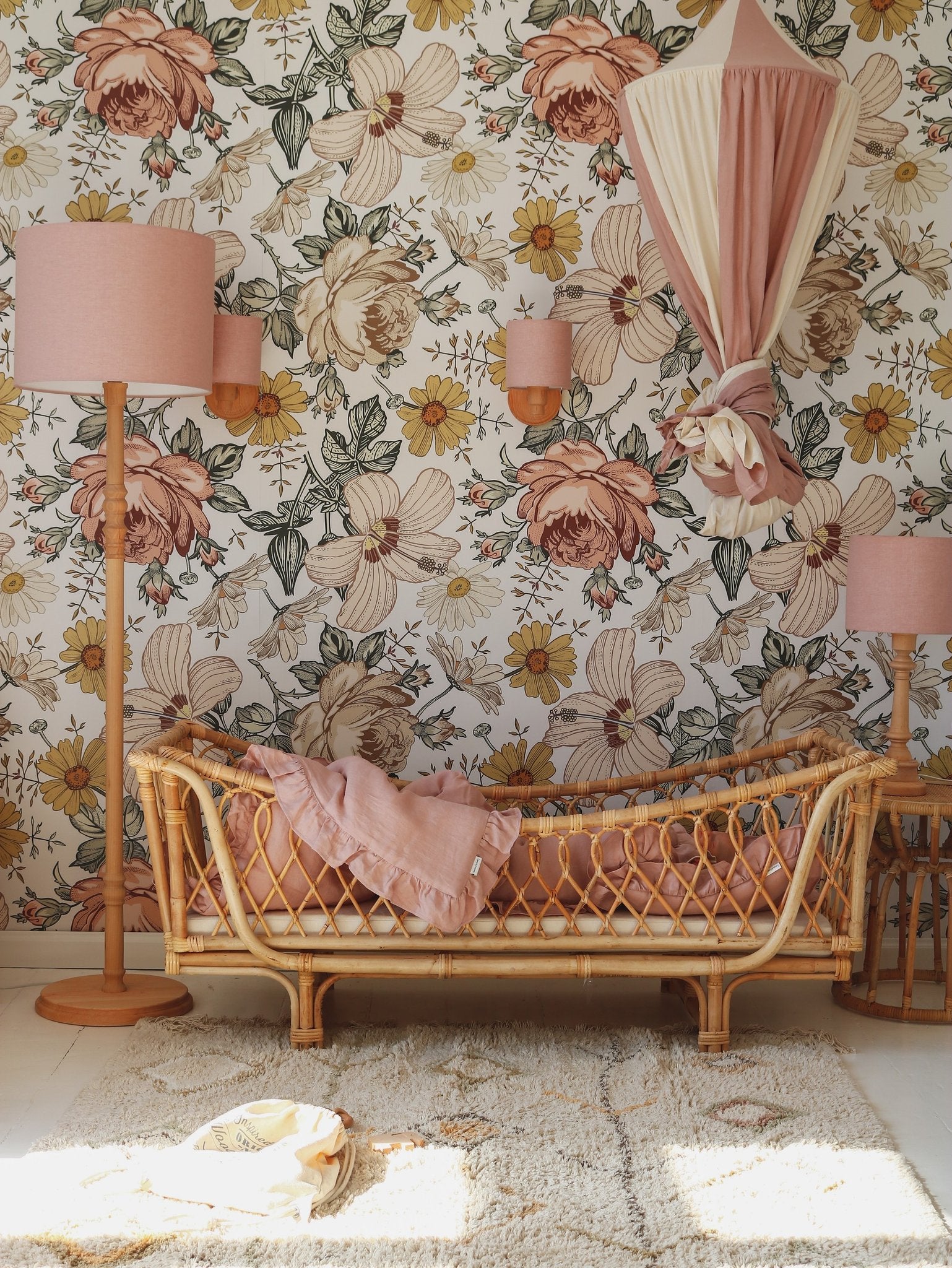 8. Powder pink and cream canopy in a floral-themed room with wicker furniture, creating a vintage and cozy ambiance.