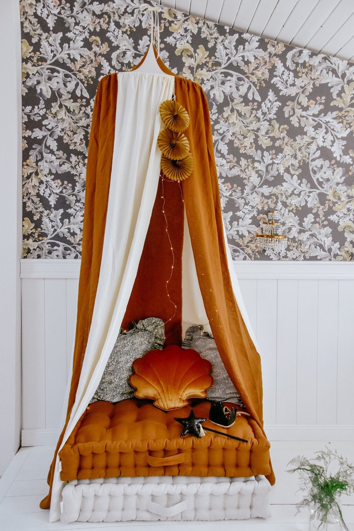 2. Caramel and cream canopy over a cozy bed with decorative pillows and floral wallpaper