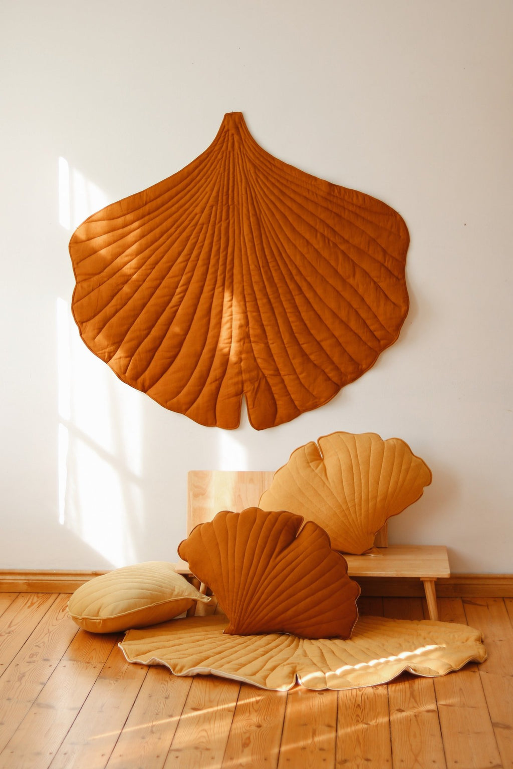 1. Room setting with caramel ginkgo leaf playmat and matching cushions, highlighting decorative and functional use
