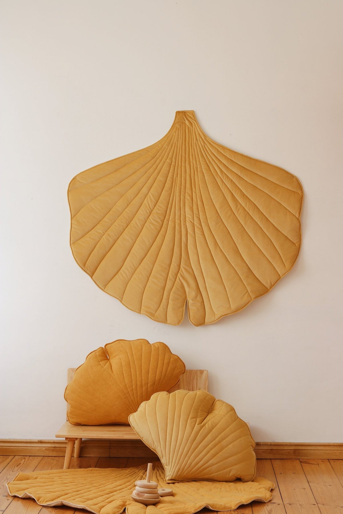6. Yellow ginkgo leaf playmat with matching cushions on a wooden floor