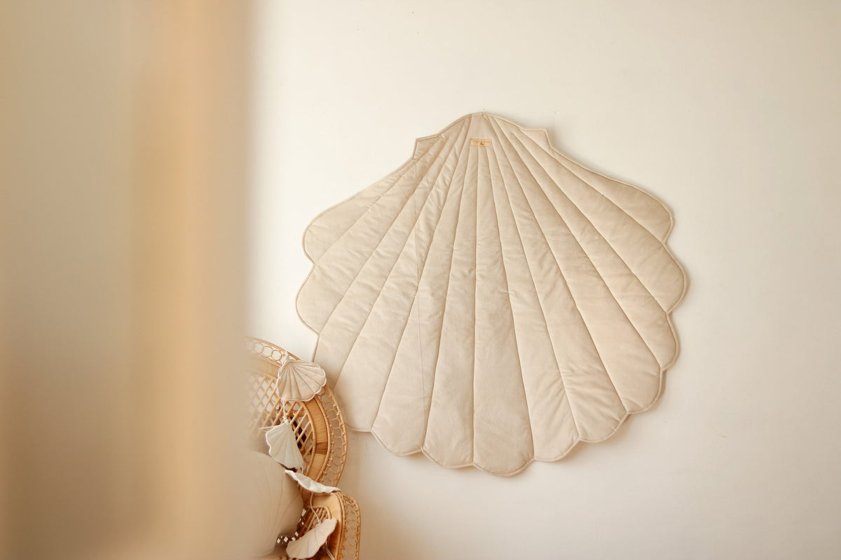 1. Beige ginkgo leaf-shaped playmat hanging on a wall in a cozy room setting