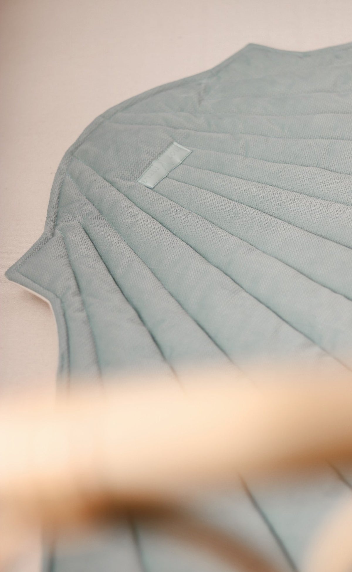 3. Close-up of mint green shell playmat showing quilted texture and stitching detail