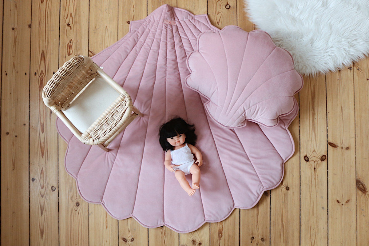 9. Overhead view of powder pink shell playmat with doll and rattan chair