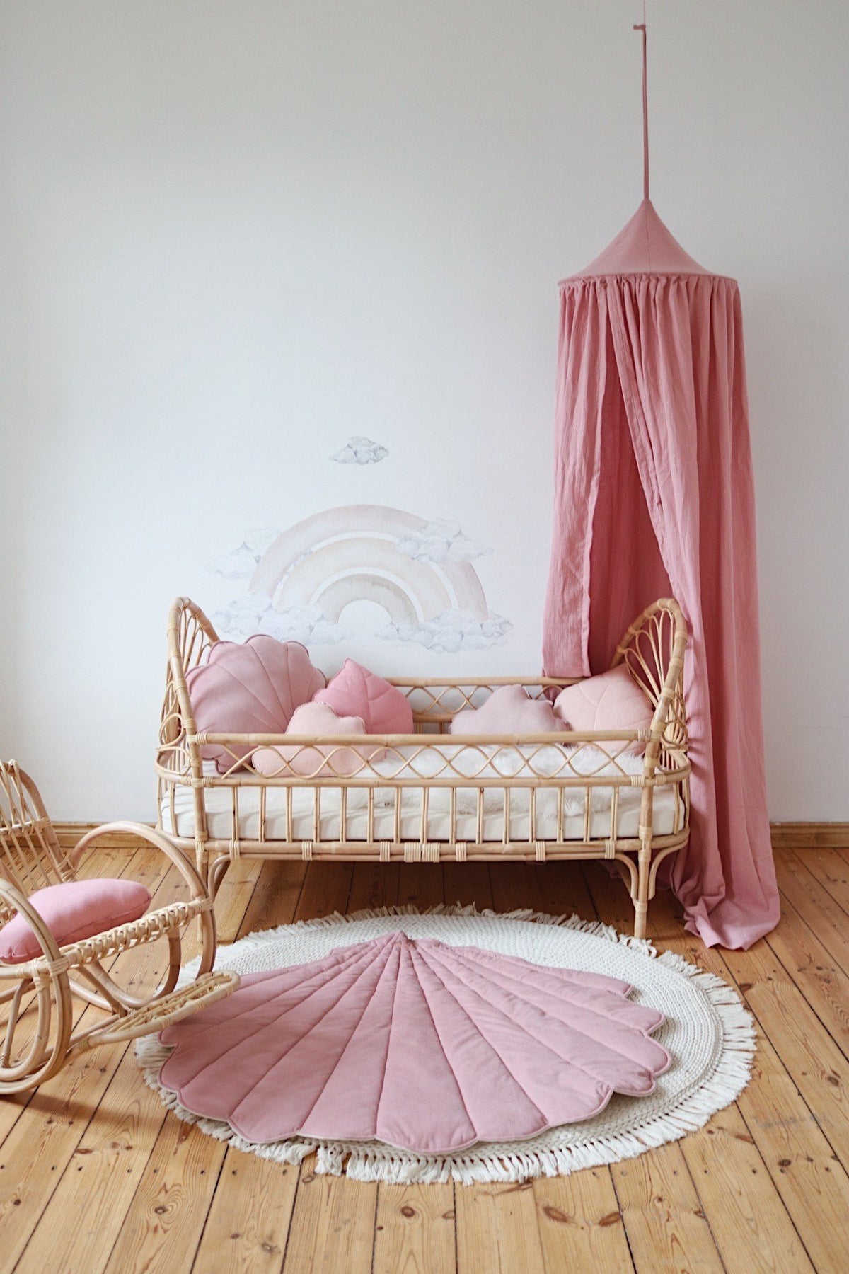 2. Powder pink shell playmat in a nursery with rattan furniture and pink canopy