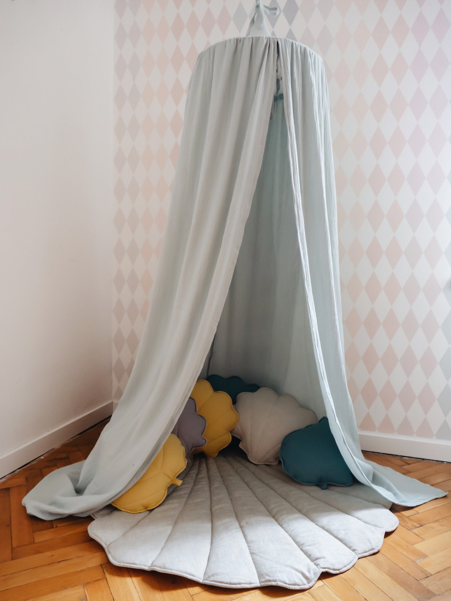 7. Mint green canopy with scalloped mat and colorful pillows in a corner setting