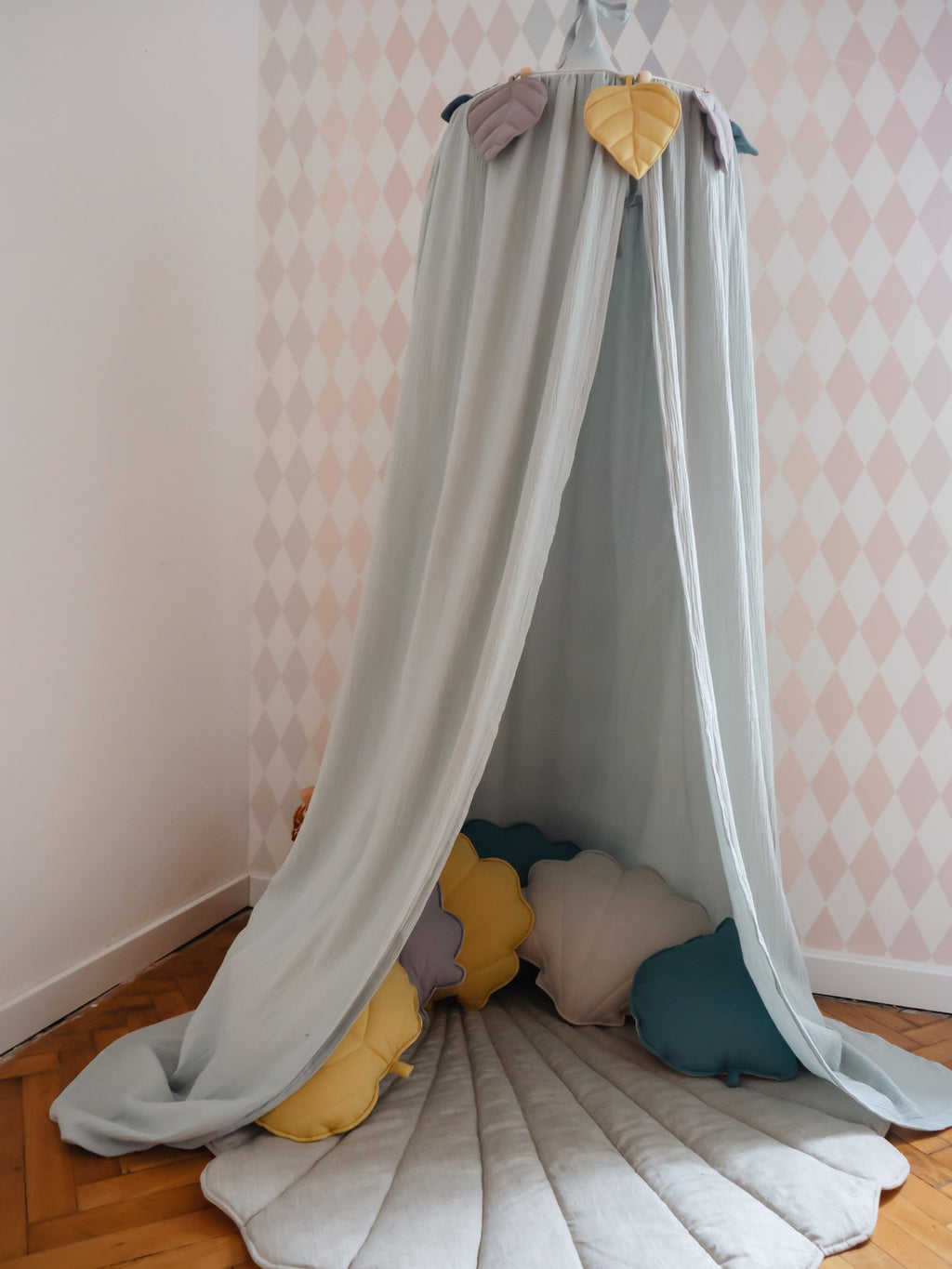 5. Mint green canopy with colorful pillows and quilted mat in a corner