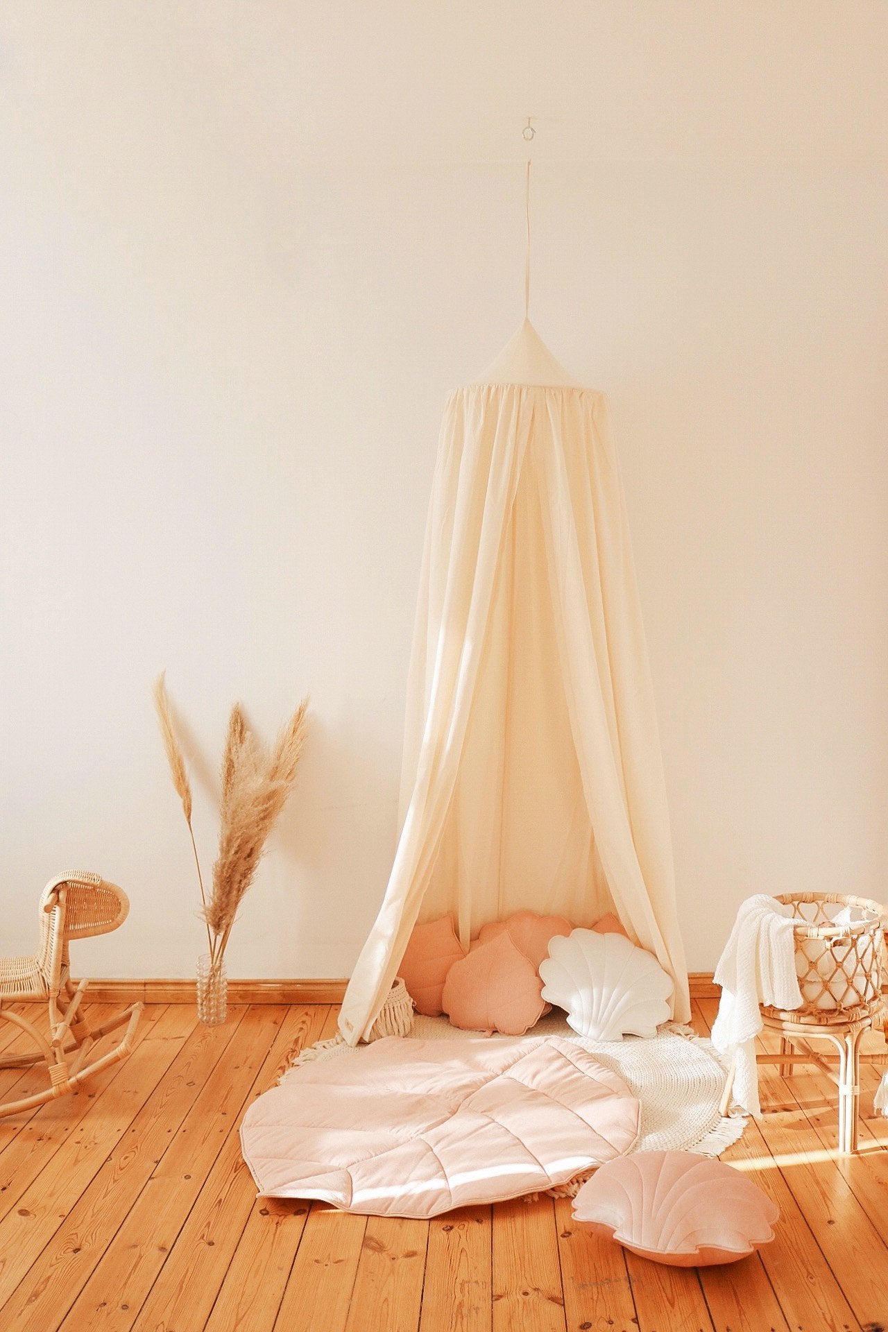 5. Organic cotton canopy in play area with pink and white cushions on wooden floor