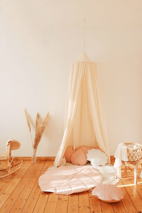 5. Organic cotton canopy in play area with pink and white cushions on wooden floor