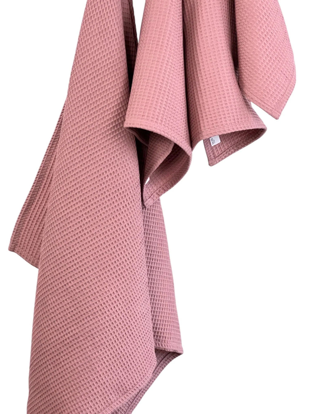6. Detail of old pink waffle cotton towels hanging, emphasizing fabric texture