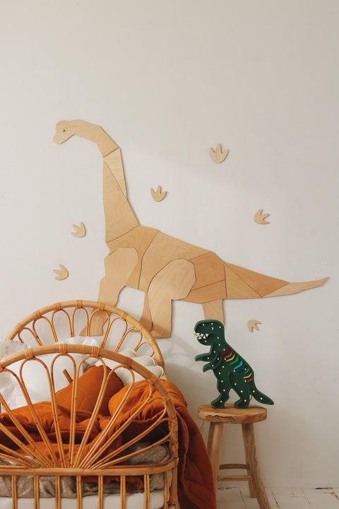3. Wooden diplodocus wall decoration above rattan chair with dinosaur toy and orange bedding