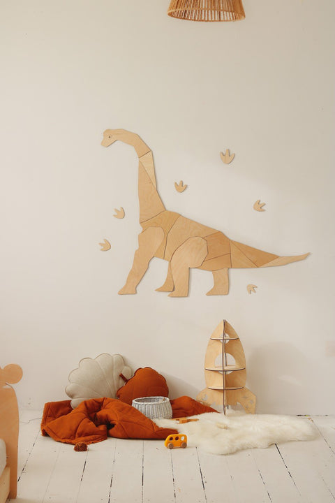 2. Wooden diplodocus wall art in child's room with orange bedding and plush toys