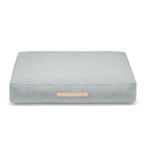 2. Studio shot of Labbvenn Oslo Cushion in light grey with leather label, showcasing minimalist design and premium materials