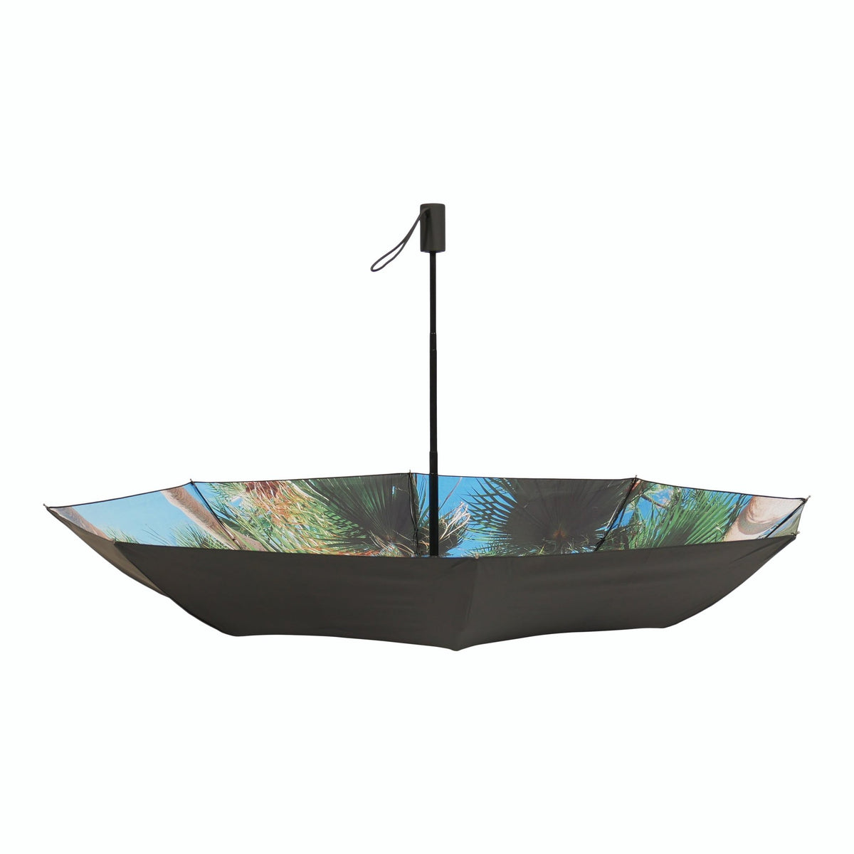 2. Studio shot of open Paradise Umbrella with tropical print and black exterior, highlighting windproof structure