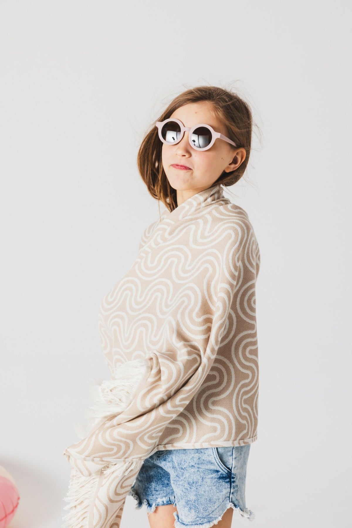 1. Girl wearing beige Patulove bamboo towel with hood and sunglasses in a studio setting