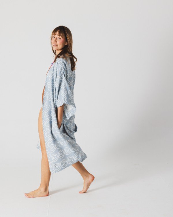 2. Woman walking barefoot in Patulove blue bamboo kimono with swirl pattern in studio