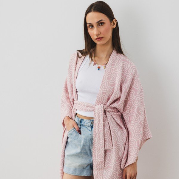 1. Woman wearing Patulove rose bamboo kimono with white top and denim shorts, standing against a white wall