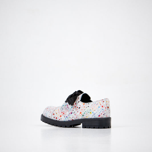 2. Unisex Samelin Dotted Widgets sneakers in white with colorful dots and black bow, angled side view in studio