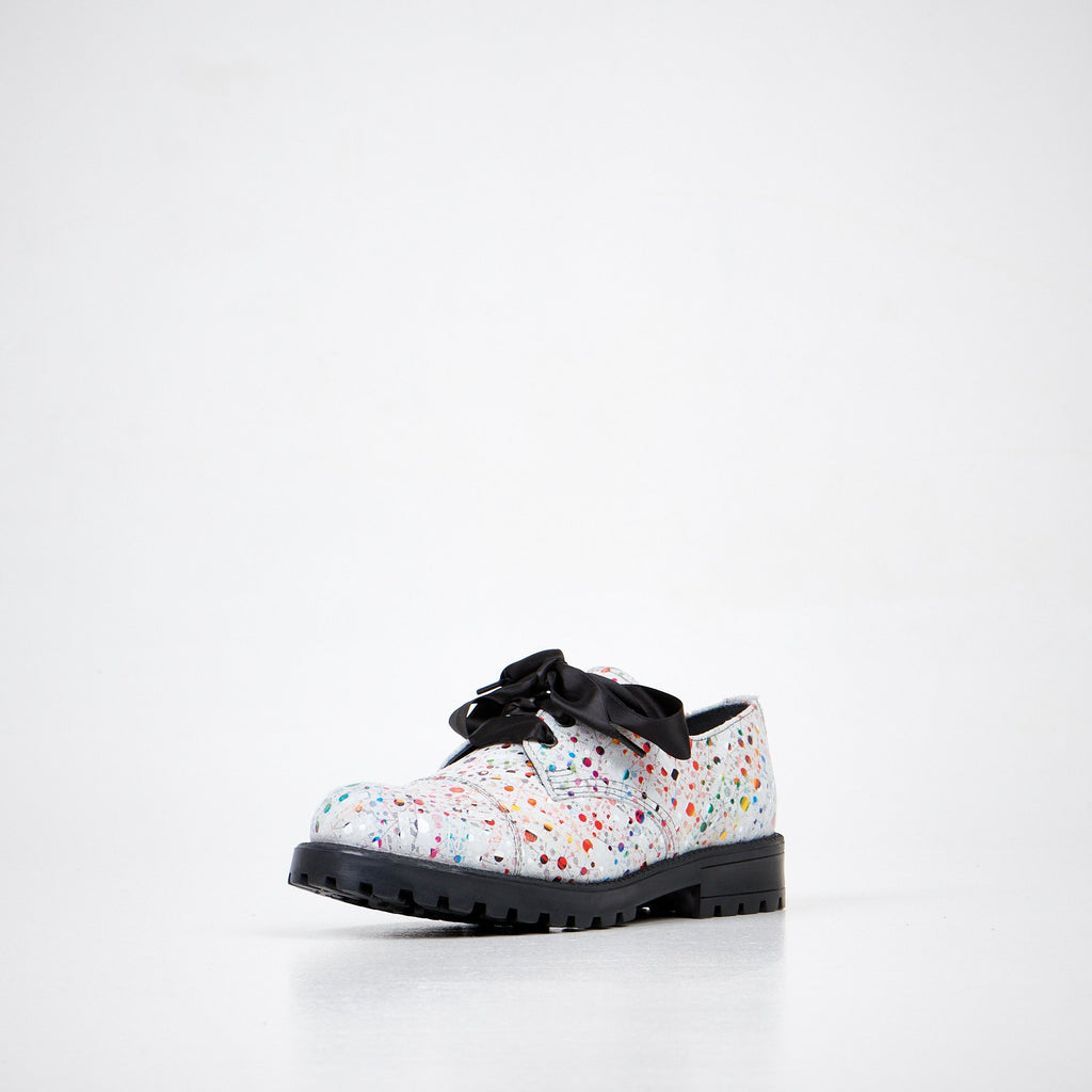 3. Unisex Samelin Dotted Widgets sneakers in white with colorful dots and black bow, front angled view in studio
