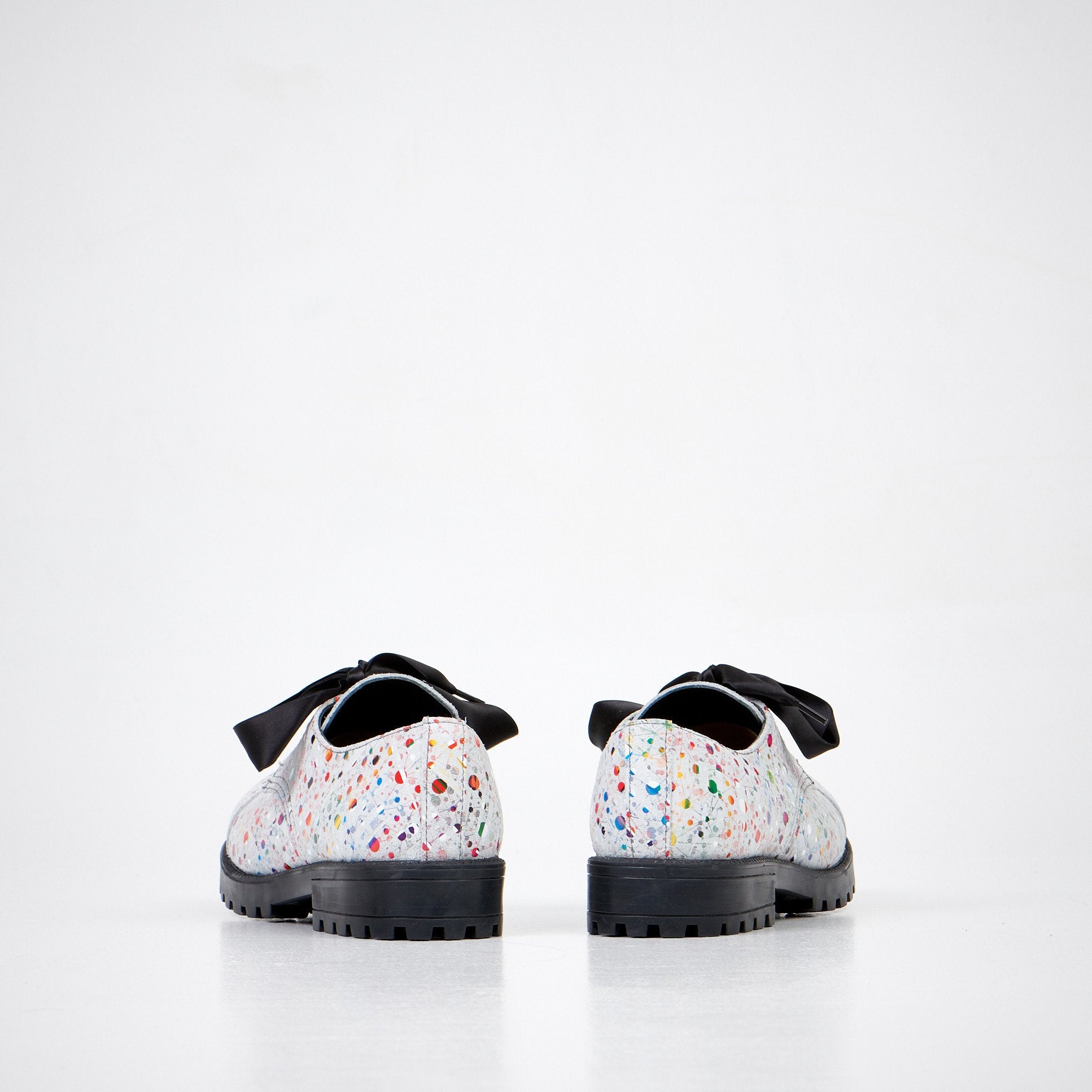 4. Unisex Samelin Dotted Widgets sneakers in white with colorful dots and black bow, rear view in studio
