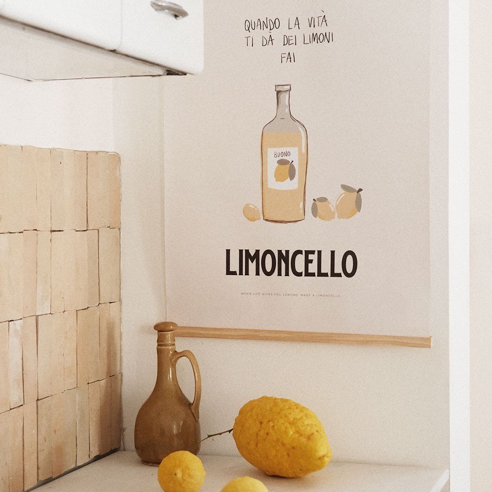 2. Terra Mamma Limoncello poster in rustic kitchen setting with lemons and ceramic jug on counter