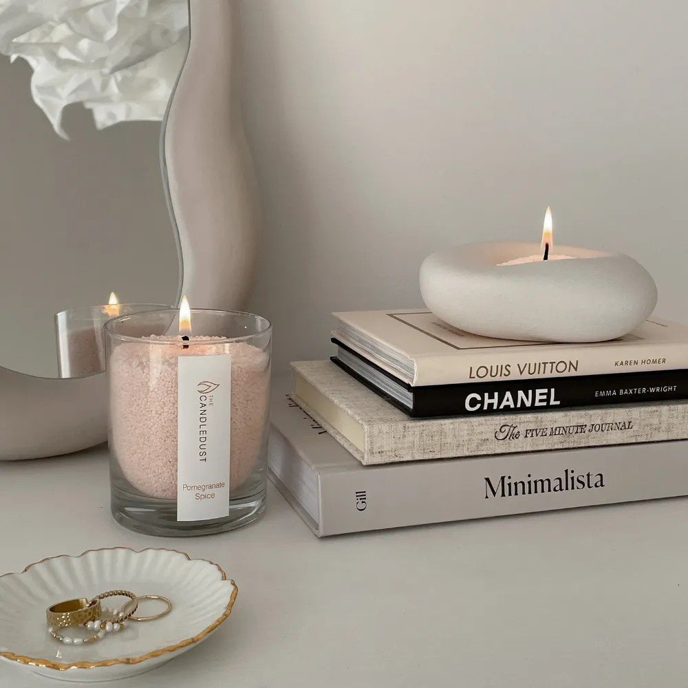1. Elegant setting with Candledust candle on books and a mirror, creating a cozy ambiance