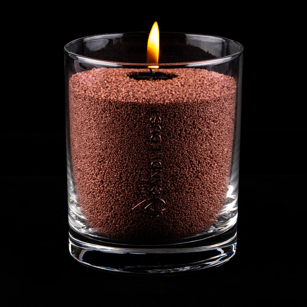 5. Pecan powdered candle in clear glass container with lit wick on black background
