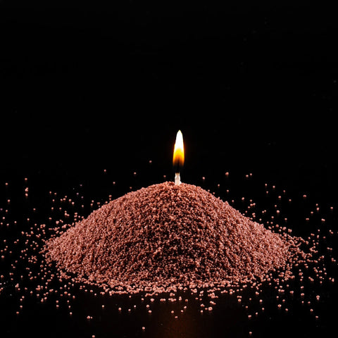 3. Close-up of lit pecan powdered candle with flame on black background